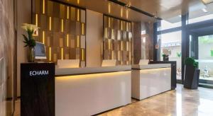 a lobby with a reception desk in a building at Echarm Hotel Aegean Shopping Park Zhonghuan Plaza in Fujiatun