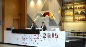 Borrman Hotel Zhanjiang Xuwen Port Terminal في Xuwen: كانتا جالستين في مكتب في مطعم