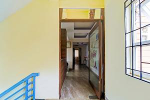 a hallway with an open door in a building at Super Hotel O Dindugal Bus Terminal Formerly GK Building in Dindigul