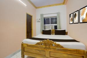 um quarto com uma cama de madeira e uma janela em Super Hotel O Patliputra Golambar em Patna