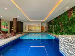 uma piscina numa casa com uma parede verde em Via Appia Tagaytay em Tagaytay