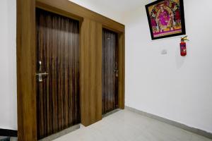 a wooden door in a room with a picture on the wall at Hotel O Sai Teerth Theme Park Formerly Sai Dhanlaxmi in Shirdi
