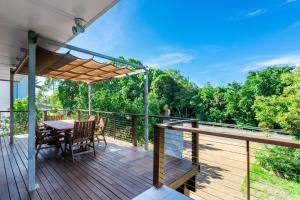 a wooden deck with a table and chairs on it at 222 On Scenic in Yeppoon