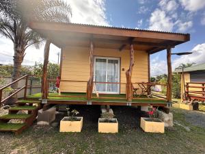 ein kleines gelbes Haus mit einer Veranda und einer Treppe in der Unterkunft Studio Karenga in La Tontouta