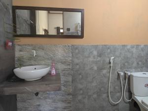 a bathroom with a sink and a mirror at Aiden Homestay in Pasikuda +62 photos