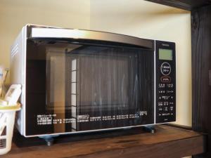 a microwave oven sitting on top of a wooden table at 農家体験民宿 古民家 薄衣 in Ichinoseki