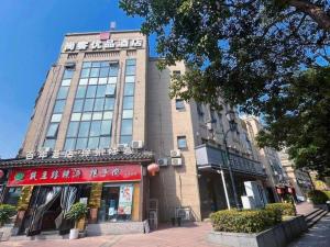 un grand bâtiment dans une rue de la ville avec un magasin dans l'établissement UP and IN Hotel Jiangsu Xuzhou Gulou District Lvdizhichuang, à Xuzhou