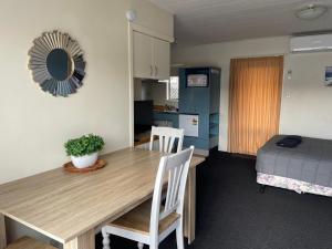 a room with a table and chairs and a bedroom at Bella Tuscany Motor Lodge in Napier