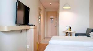 a hotel room with two beds and a flat screen tv at Jun Hotel Gansu Lanzhou Chengguan District Zhangye Road Walking Street in Lanzhou