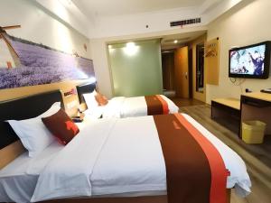 寧波市にあるJun Hotel Zhejiang Ningbo Luzhou District Zhongxing Nan Roadのベッド2台と薄型テレビ付きのホテルの部屋
