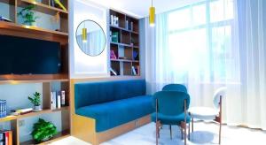 a living room with a blue couch and a tv at Magnotel Wulanhaote Hanshan Dong Street in Ulan Hot +42 photos