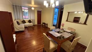 een woonkamer met een tafel en stoelen en een woonkamer bij Departamento Privado in Lima