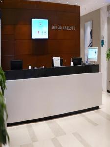 un long comptoir blanc dans un hall avec une télévision dans l'établissement City Comfort Inn Liuzhou Luzhai Walking Street, à Luzhai