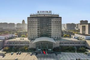 Un gran edificio con un cartel encima. en Jinjiang Hotel Qianan, en Qian'an