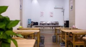 an empty restaurant with tables and machines in the background at Shell Hotel Anhui Bozhou Woyang County Lexing Road Bus Station in Guoyang +62 photos