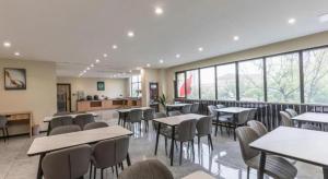 una sala da pranzo con tavoli, sedie e finestre di GreenTree Inn Express Zhangjiagang Hexing Town Shazhou Professional Institue of Technology a Qiwei