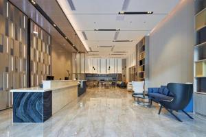 柳州にあるEcharm Hotel Liuzhou Yaobu Ancient Townの受付デスクと椅子のあるオフィスロビー
