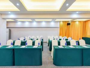 a conference room with green tables and white chairs at City Comfort Inn Yunfu Xinxing Juncheng Plaza in Xinxing