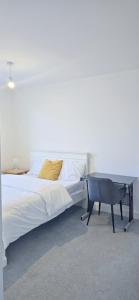 ハルにあるLovely accomodation with free parking & WiFiの大きなベッドと机のある寝室