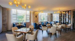 JiayuにあるEcharm Hotel Jiayulongwan Peninsulaのテーブルと椅子と窓のあるダイニングルーム