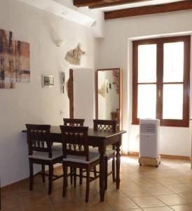 una sala da pranzo con tavolo, sedie e frigorifero di Old Town Apartment ad Alghero