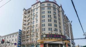 a tall white building with writing on it at City Comfort Inn Zhongxiang Mochou Avenue in Zhongxiang