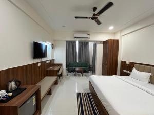 a hotel room with a bed and a tv at Krishna Anandam Palace-Near Prem Mandir in Vrindāvan