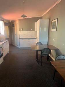 a kitchen with a table and chairs in a room at Premier Hotel Collie in Collie