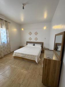 une chambre avec un grand lit et un miroir dans l'établissement Grand T2 Bwereny'S Lodge - Passamainty, à Mamoudzou