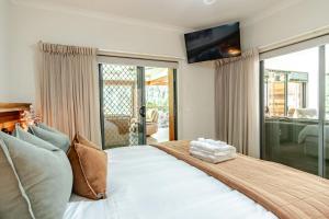 a bedroom with a large bed with a television on the wall at Creek Haven in Bright
