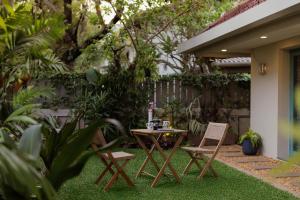 a patio with a table and chairs on the grass at Mammootty House Kochi - a VKation Experience in Cochin