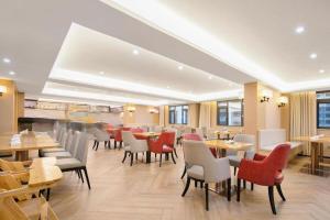 a restaurant with wooden tables and chairs and tables and chairs at Echeng Hotel Enshi Minzu Road in Enshi