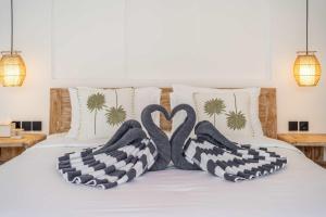 zwei Schwäne, die auf einem Bett eine Herzform machen in der Unterkunft New 1BR Pool Villa in Bingin-Uluwatu in Uluwatu + 12 Fotos