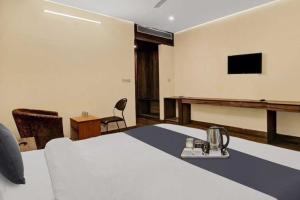 Gomti NagarTownhouse Gomti Nagar Station Formerly Budget In的客房设有一张床、一张书桌和电视