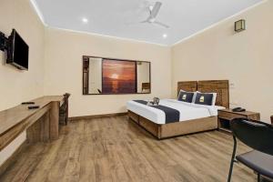 a bedroom with a bed and a desk and a television at Townhouse Gomti Nagar Station Formerly Budget In in Gomti Nagar +26 photos