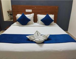 a bed with blue and white sheets and blue pillows at Hotel O Rajahmundry Central Railway Station Formerly Sanjeevi Residency in Godāvari