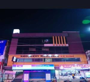 a building with neon signs in front of it at Hotel O Rajahmundry Central Railway Station Formerly Sanjeevi Residency in Godāvari