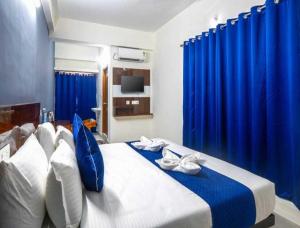 a bedroom with a bed with blue drapes at Hotel O Rajahmundry Central Railway Station Formerly Sanjeevi Residency in Godāvari