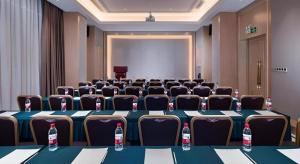 une salle de conférence avec une grande table et des chaises dans l'établissement Vienna Hotel Guangdong Shaoguan Shaonan Avenue, à Leyuan