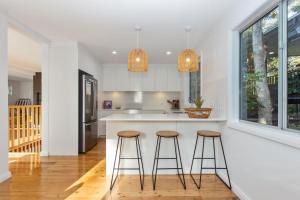 a kitchen with two bar stools at a counter at Jimmys Beach House in Hawks Nest