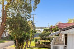 a street view of a house with a tree at Jimmys Beach House in Hawks Nest