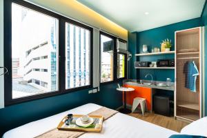 a room with a bed and a kitchen with windows at Trybe CoLiving in Cebu City