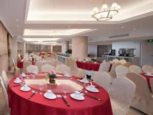 XinfengにあるVienna Hotel Xinfeng West High-Speed Railway Stationの赤いテーブルと白い椅子が備わる宴会場