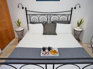 a bed with a plate of food and two cups on it at Villa Jenny Stylianou in Spetses