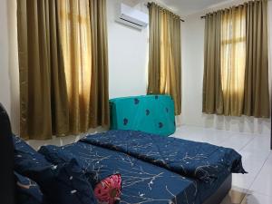 パダン・ブサールにあるChek Embun Homestayのベッドと青い椅子が備わる客室です。