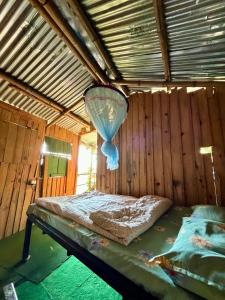 a room with a bed with a light hanging from the ceiling at Pemsee's Tree Town - Eco Treehouse Hostel in Sauraha