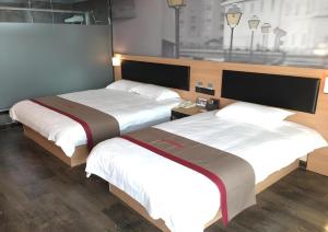 two beds in a hotel room with two bedsskirts at Thank Hotel Shandong Weifang North High-speed Railway Station in Weixian