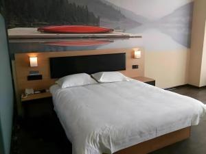 a bedroom with a large white bed with two pillows at Thank Hotel Shandong Weifang North High-speed Railway Station in Weixian +42 photos