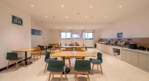 une grande salle avec des tables et des chaises dans une cafétéria dans l'établissement City Comfort Inn Changning Wangchao, à Changning