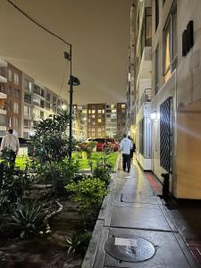 two people walking down a city street at night at bonito departamento cerca al Aeropuerto Jorge Chávez in San Antonio